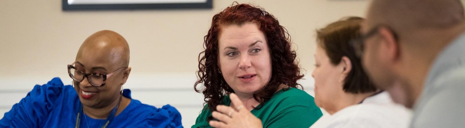 Four diverse individuals communicating in sign language