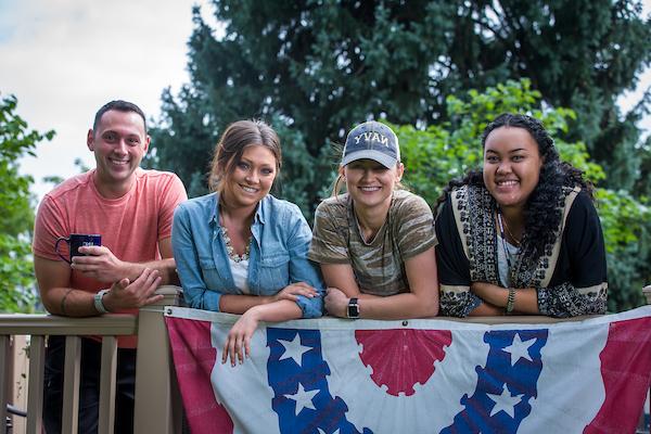 Four students smiling on the deck of Roudebush Cottage